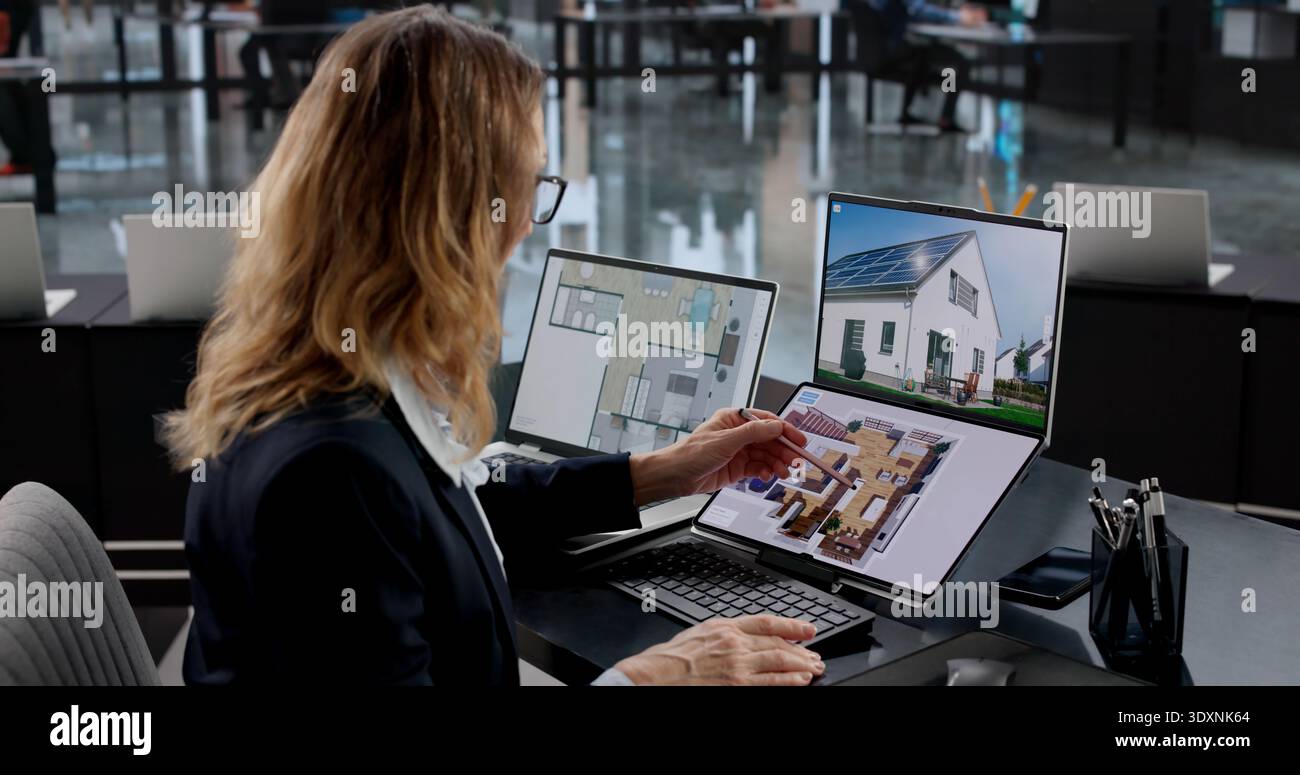 Female Real Estate Agent Using CAD Software For Interior Design Stock Photo