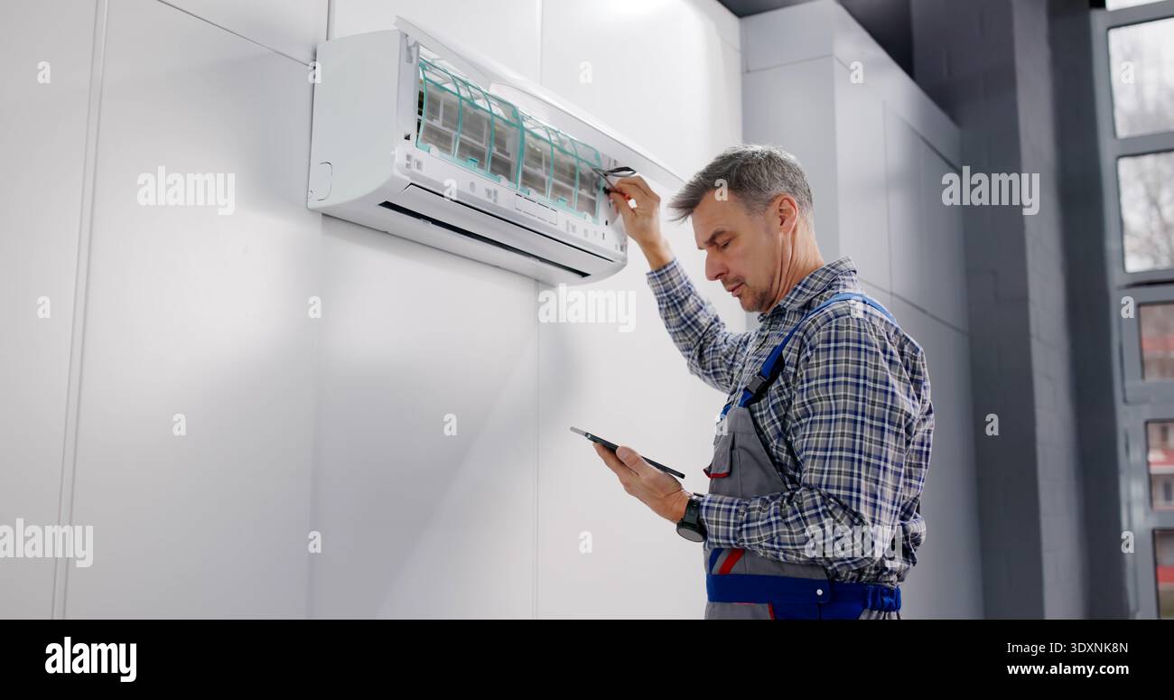 Commercial HVAC Technician Performs Air Conditioner Repair Using Tablet Report. Stock Photo