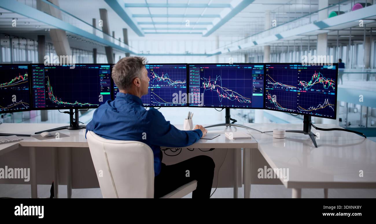 Senior Stock Broker Analyzing Market Data On Multiple Computer Screens. Stock Photo