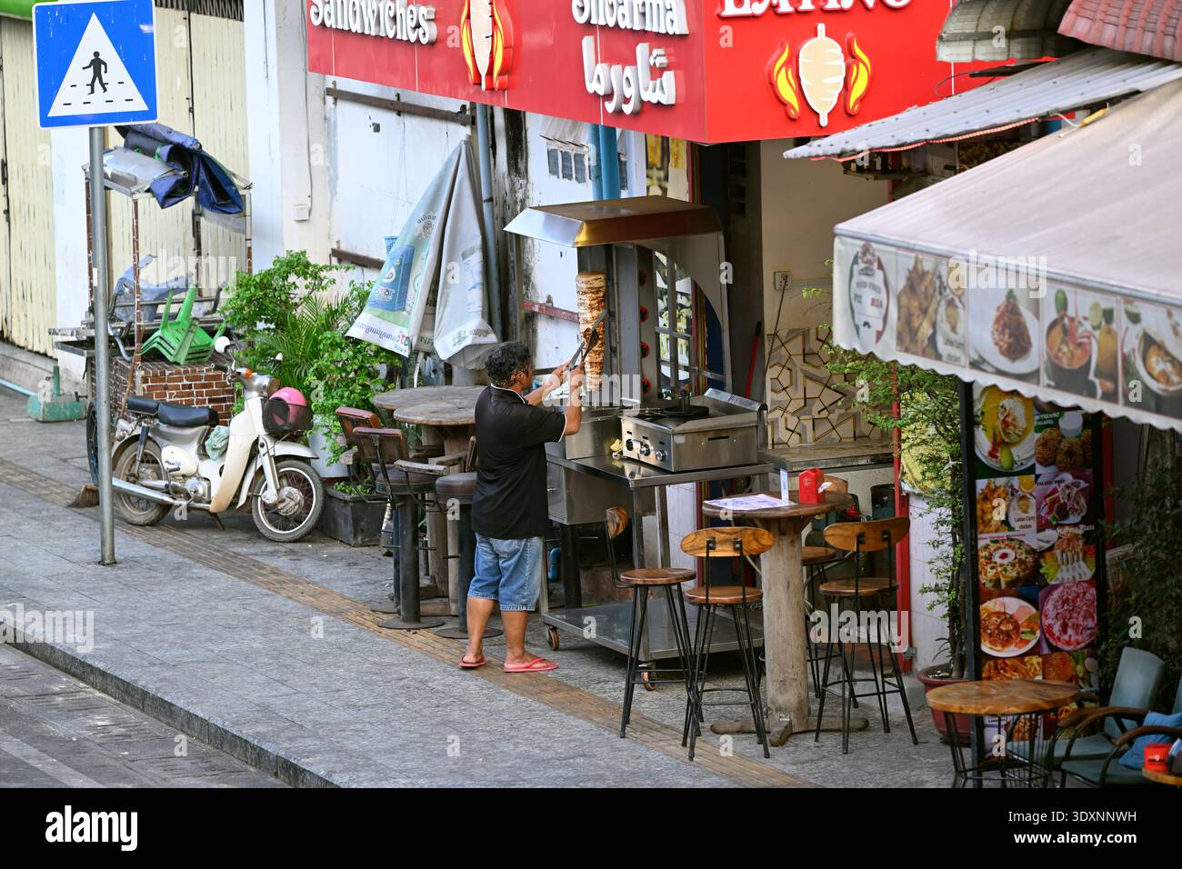 A man slices ckicken to make shwarma at a restaurant in Siem Reap, Cambodia. Stock Photo