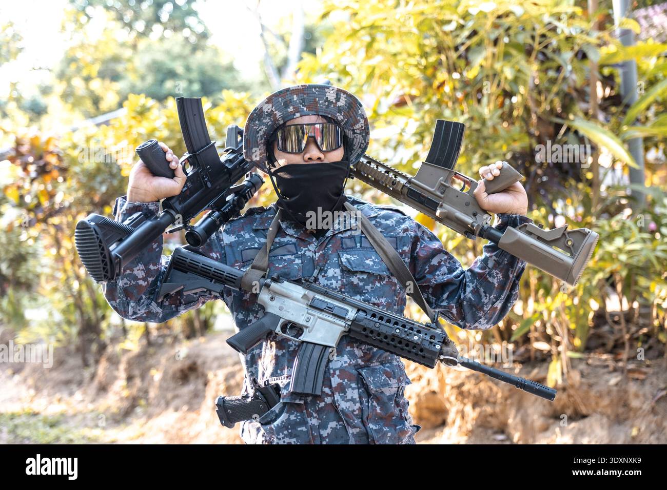 Confident soldier in camouflage uniform holding military rifle and ...