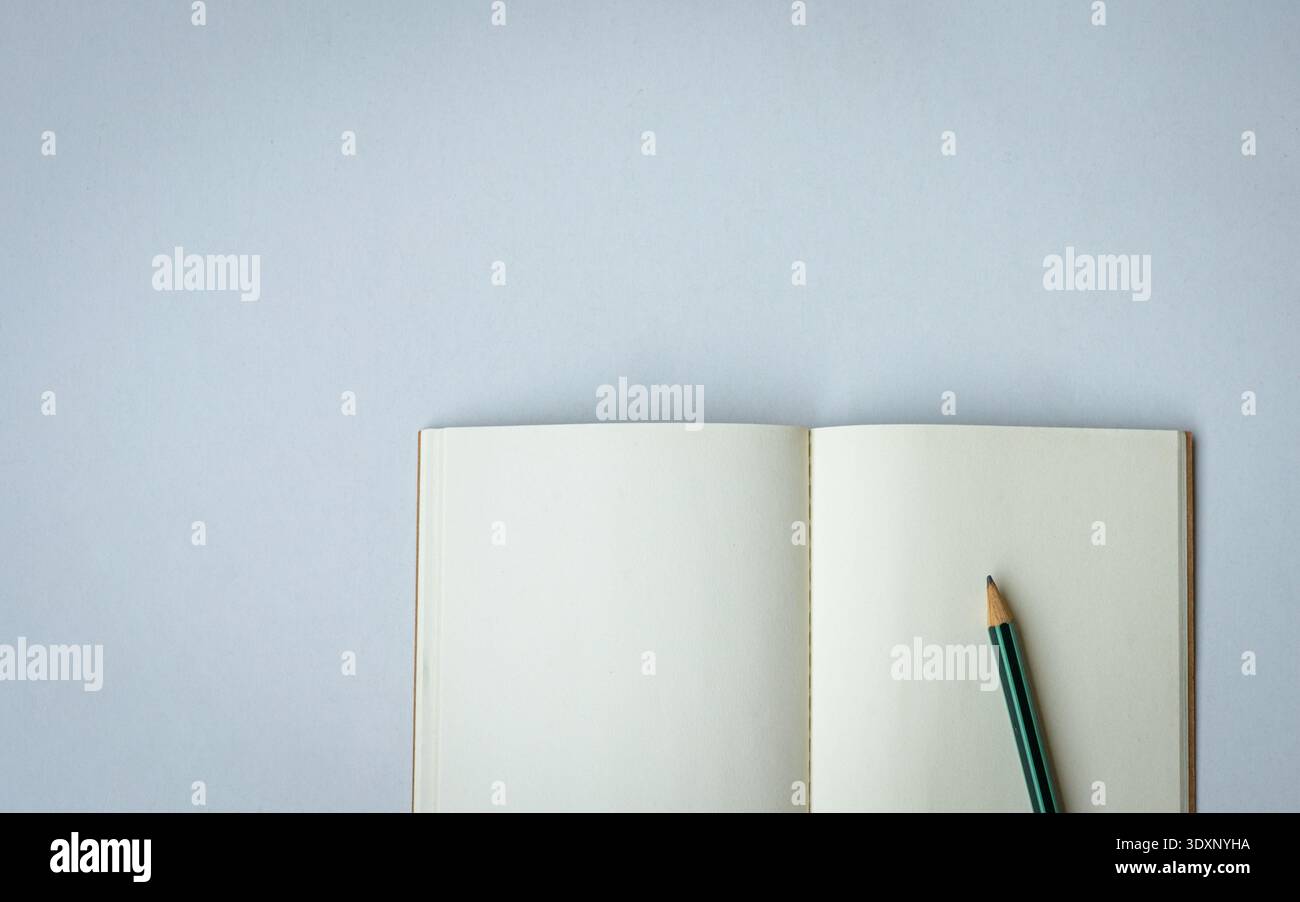 Open notepad with one pencil. Top view. Space for text. Stock Photo