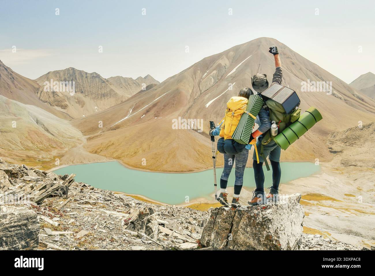 Couple of hikers reaching top celebrate hands up on top peaken joy caucasus panorama outdoors.Victorious couple adventurers friends trek or hike trave Stock Photo