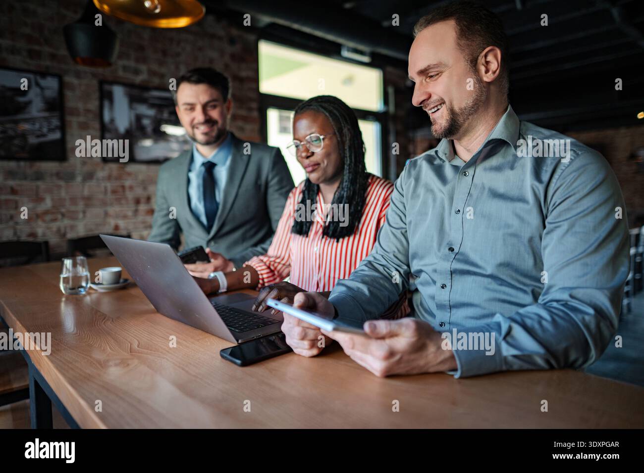 Business people collaborating on project using laptop and digital tablet Stock Photo