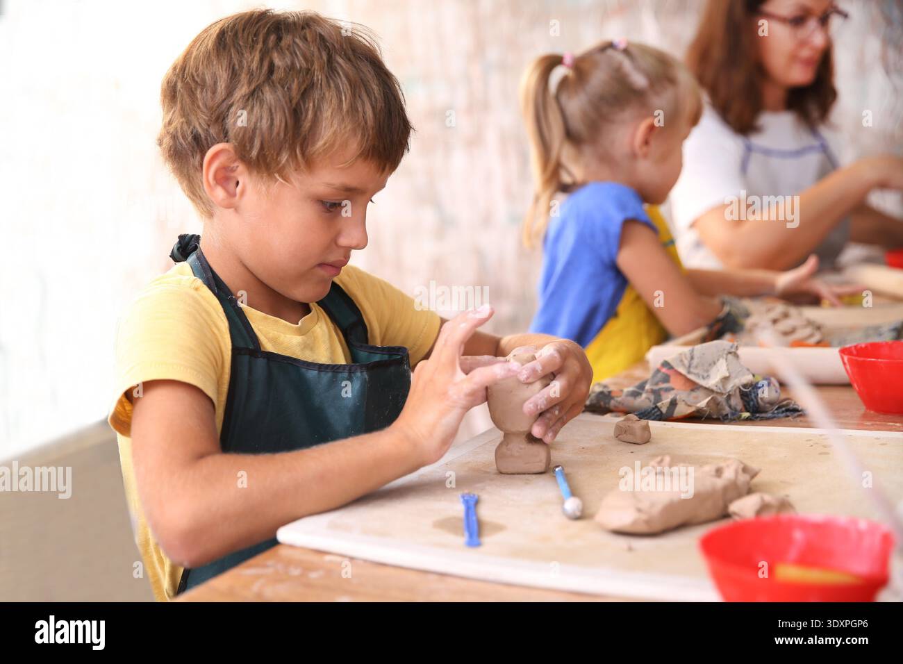 Kids molded from clay at pottery class. || Model released Stock Photo