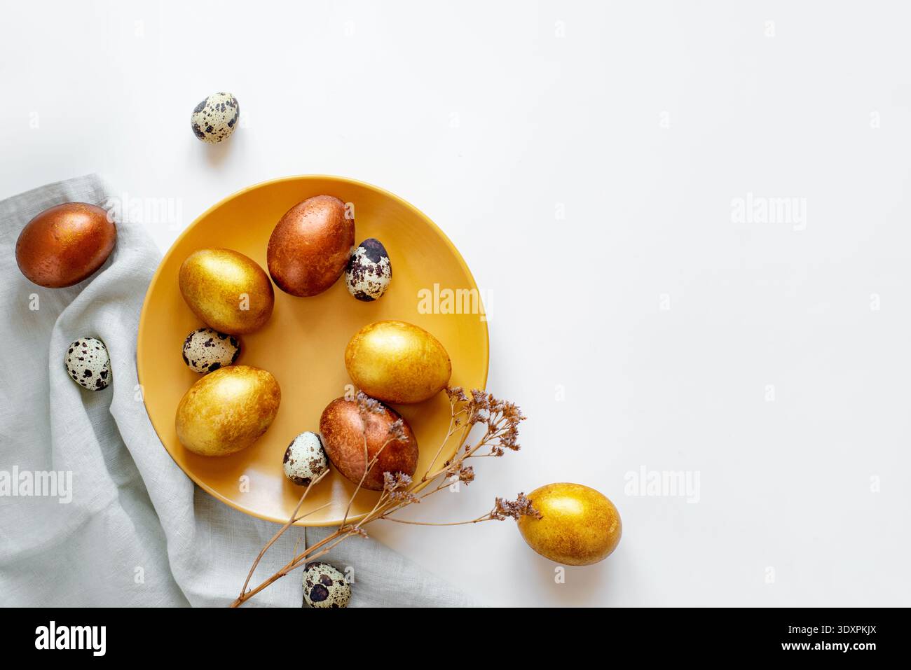 Golden and bronze Easter eggs in a orange plate Stock Photo