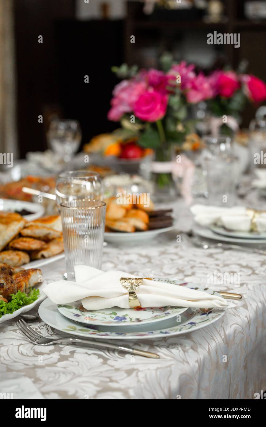 Elegant Dinner Table Setting with Pink Roses and Appetizers Stock Photo