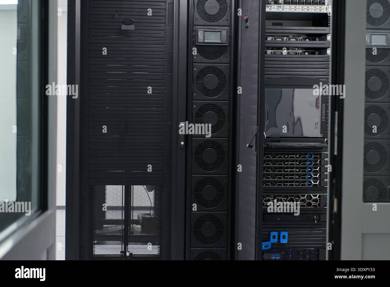 Modern server racks inside a secure data center room showing network equipment and storage infrastructure Stock Photo