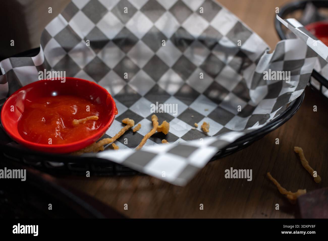 Empty food basket with checkered paper red sauce and fried crumbs Stock Photo