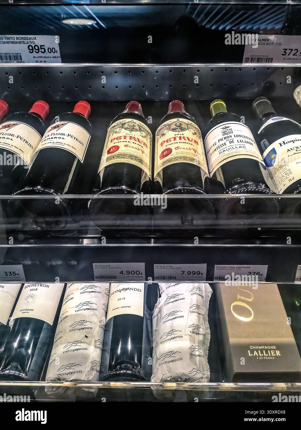 A selection of premium wines, including Chateau Petrus 2011 and 2018, displayed in a Madrid supermarket. Madrid, Spain - November 30, 2021 - Smartphone Captured Stock Image