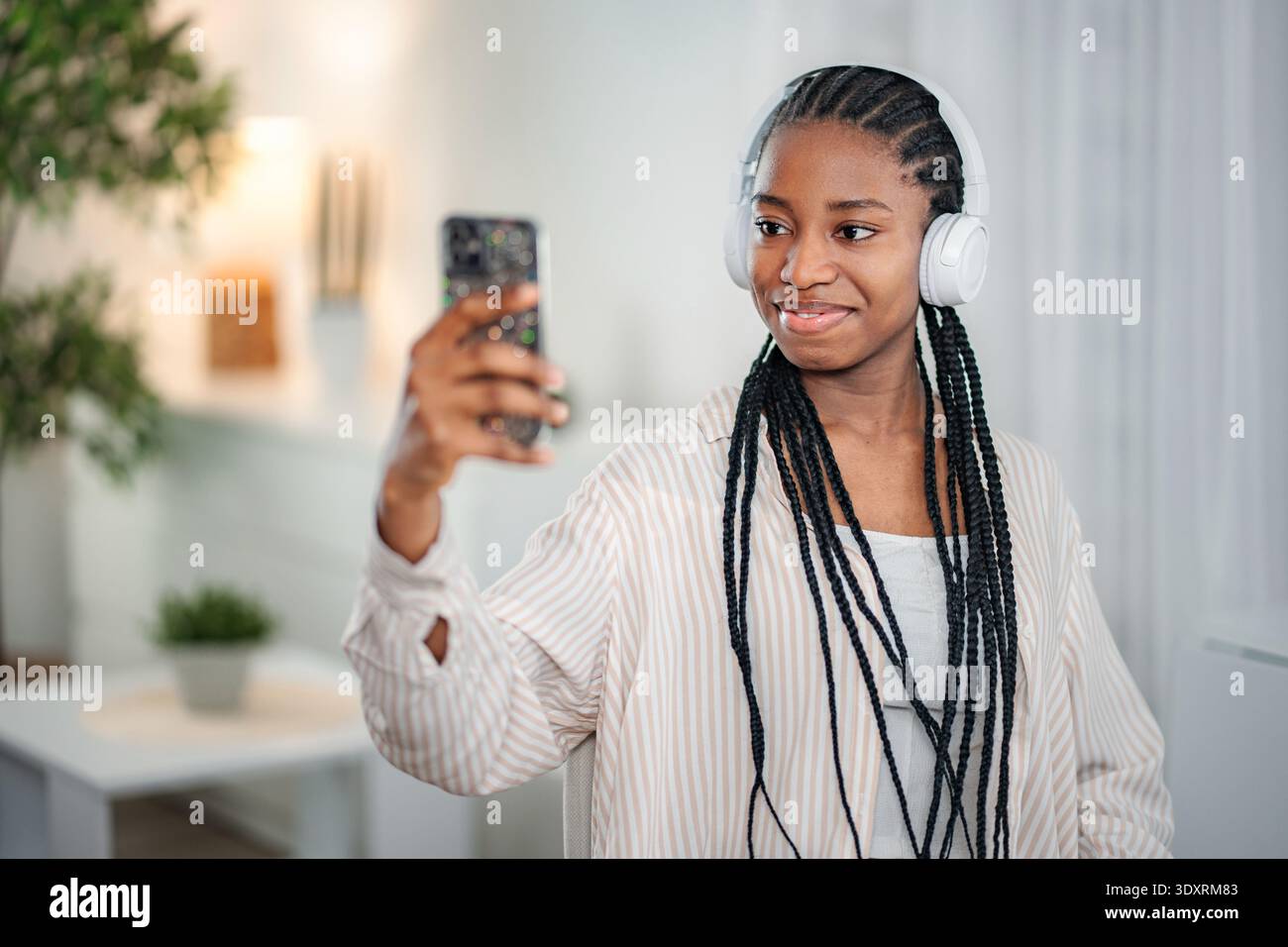 Young woman wearing headphones using smartphone for content creation Stock Photo