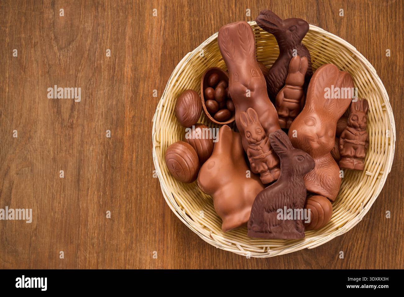 Basket filled with assorted chocolate bunnies and easter eggs Stock Photo