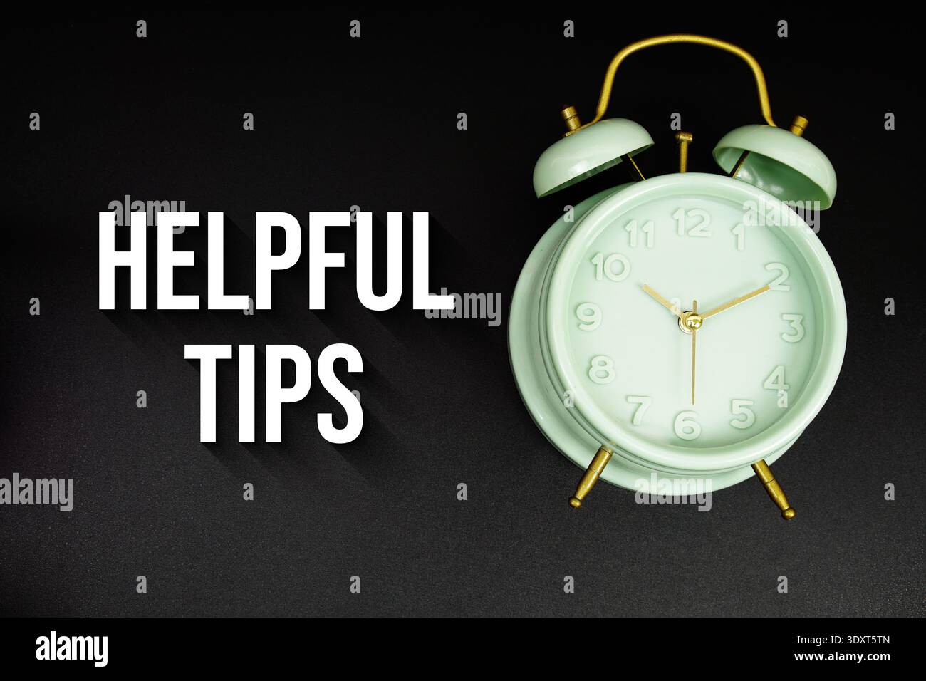 Helpful Tips text with alarm clock on black background Stock Photo