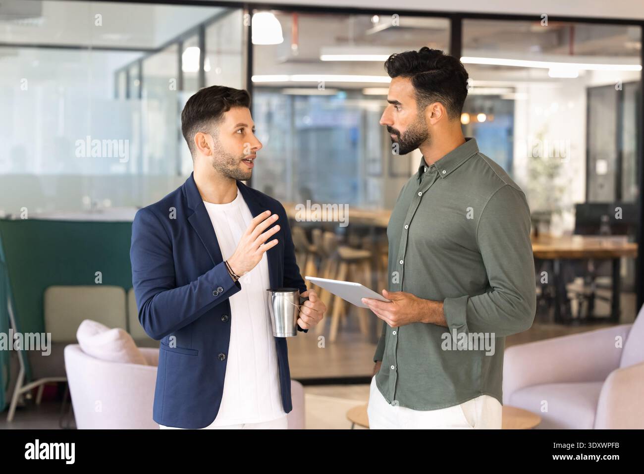 Male colleagues talking during work break in office Stock Photo