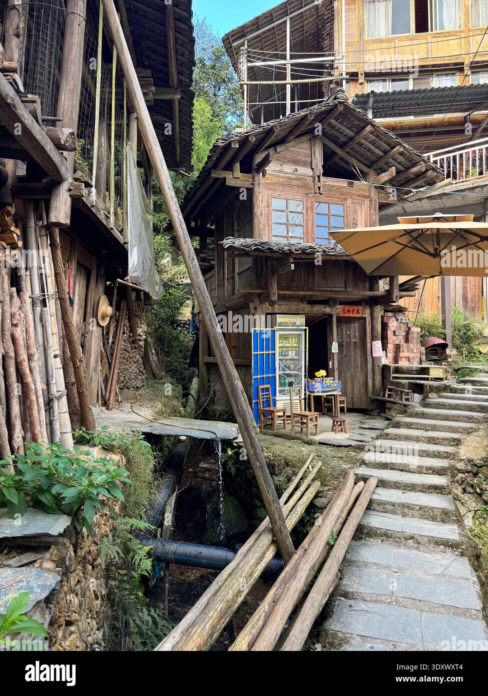Traditional wooden village houses in Longji, Guangxi, China, rustic rural life with narrow alley and mountain settlement. - Smartphone Captured Stock Image