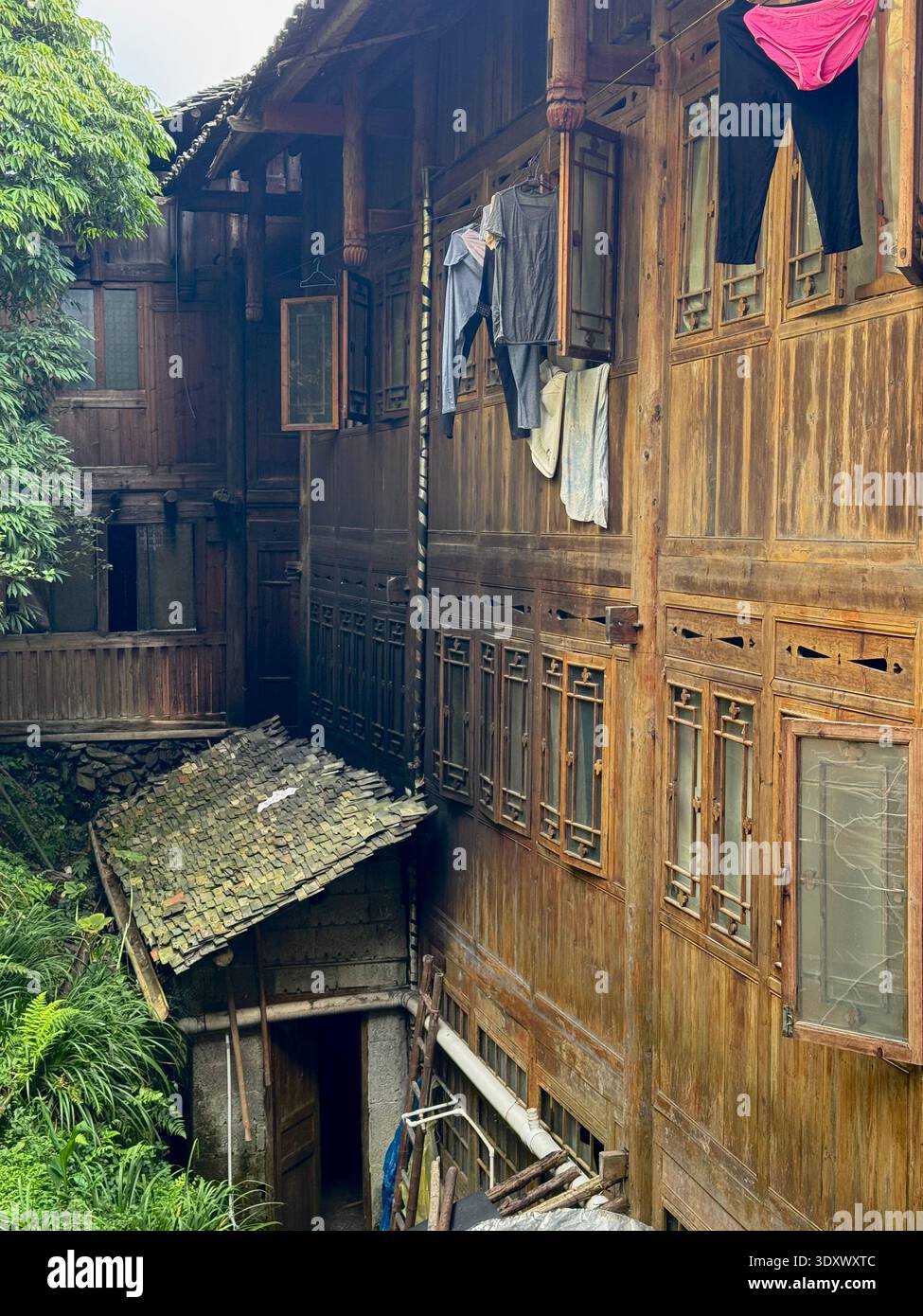 Traditional wooden village houses in Longji, Guangxi, China, rustic rural life with narrow alley and mountain settlement. - Smartphone Captured Stock Image
