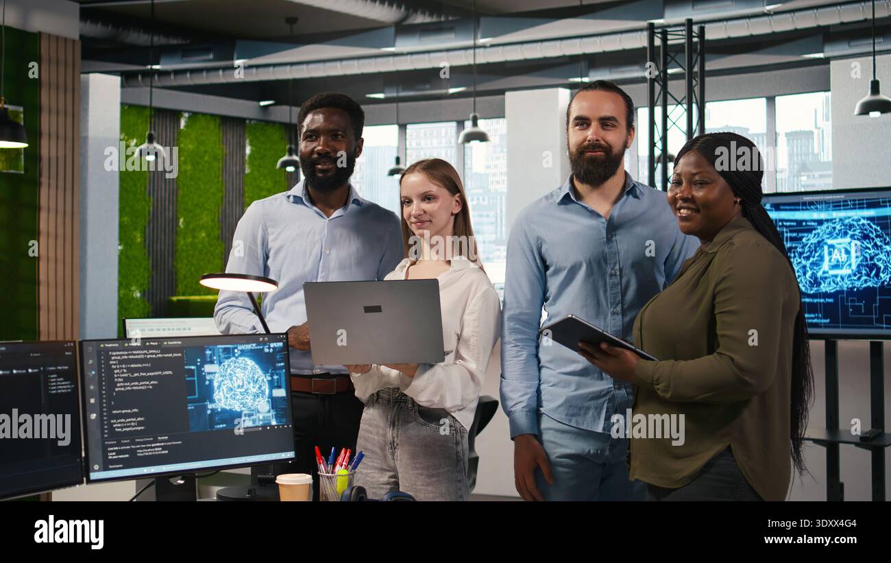 Team of programmers in office automating repetitive tasks using AI scripts on devices. Teamworking IT experts brainstorming, using artificial intelligence to speed up feature implementation, camera A Stock Photo