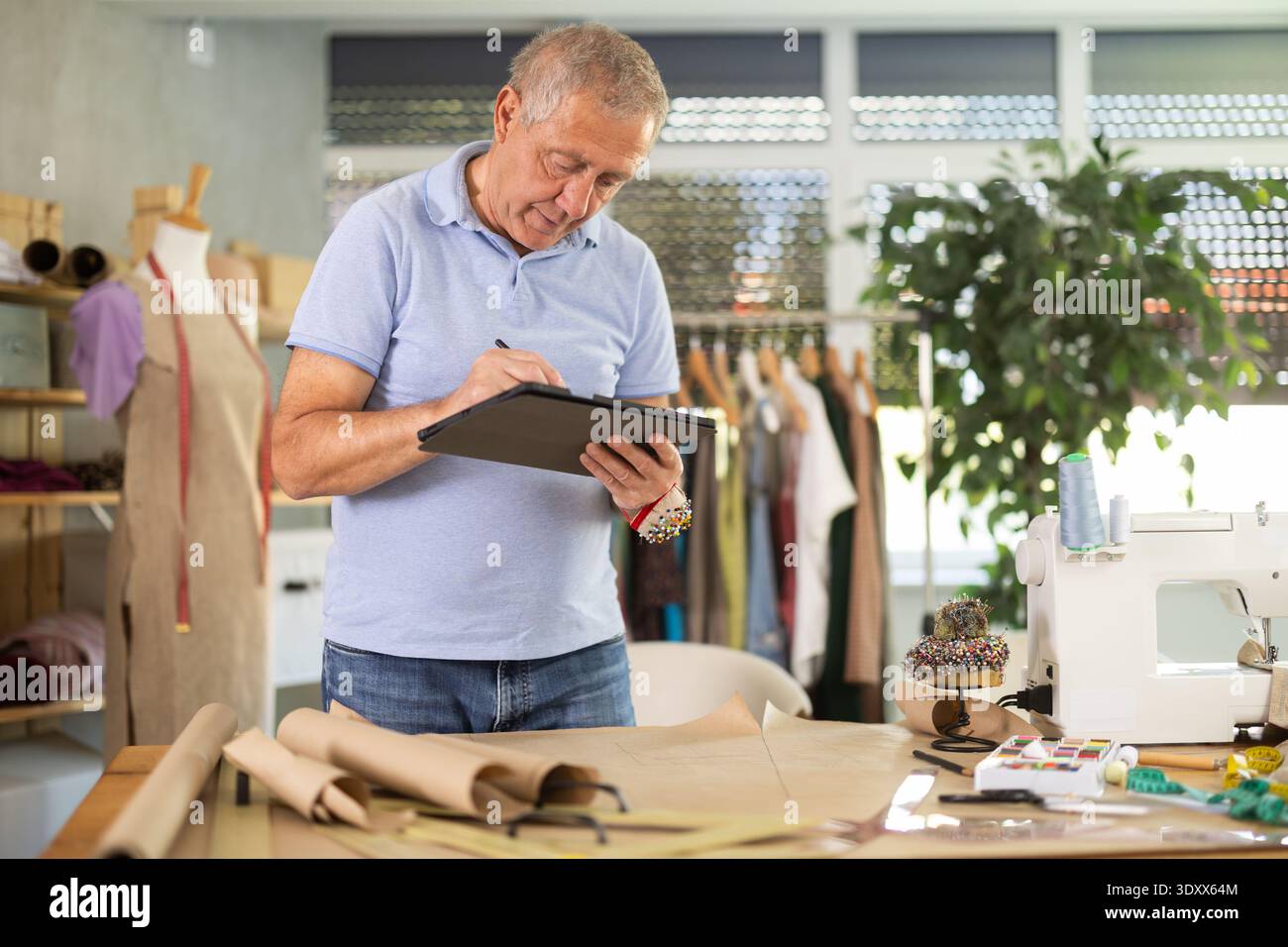 Man tailor makes pattern using tablet Stock Photo
