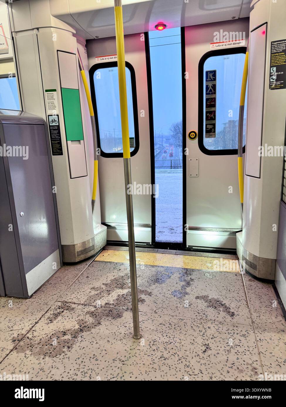 Interior of a commuter train with cloing doors during winter weather, viewed from inside public transport with city traffic visible through doors. - Smartphone Captured Stock Image