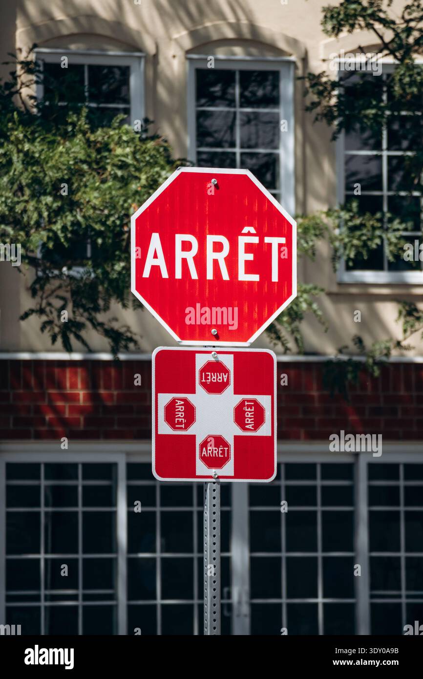 Red Arrêt stop sign with Quebec four-way stop symbol on a city street ...