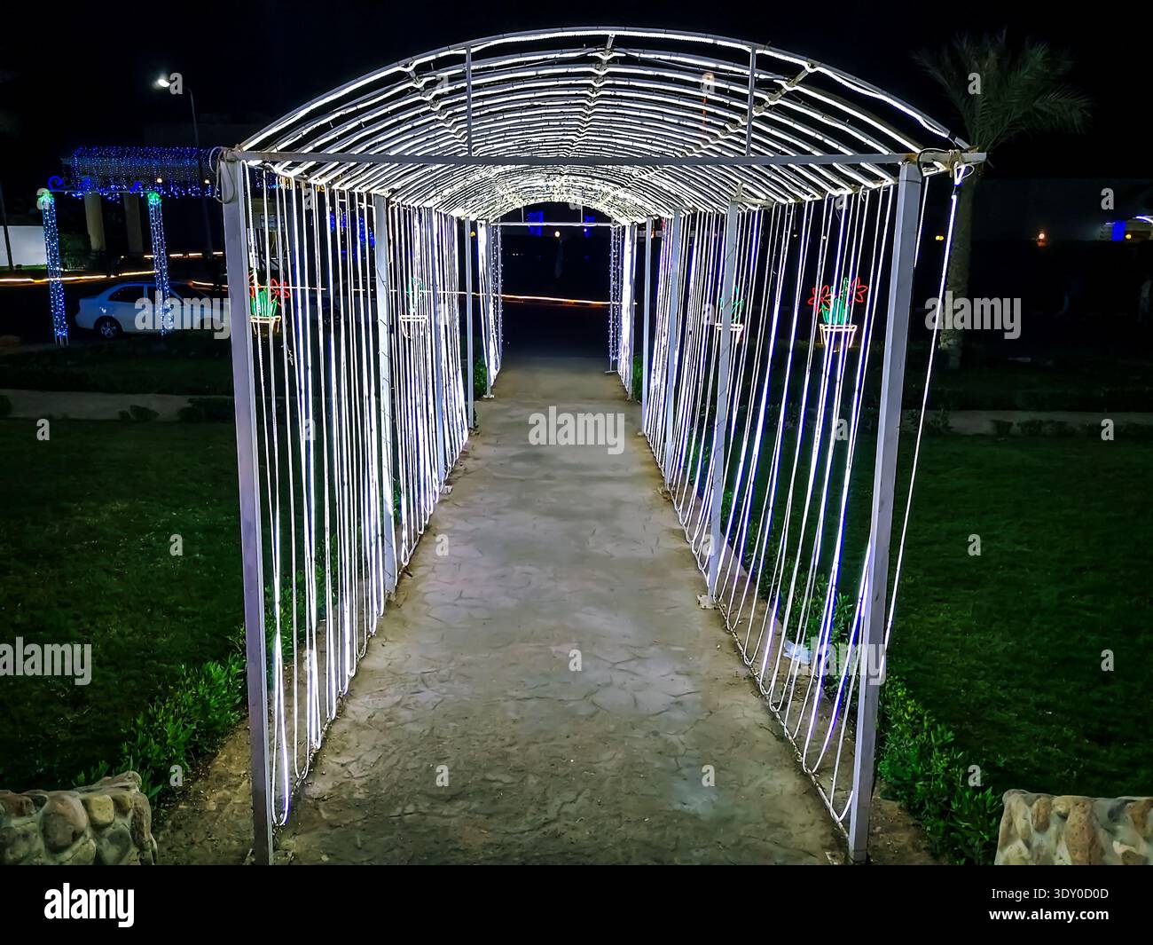 Egypt, Sharm El Sheikh - January 18, 2020: Tunnel illuminated by diode lights at night in Soho. Glowing corridor on a dark background - Smartphone Captured Stock Image