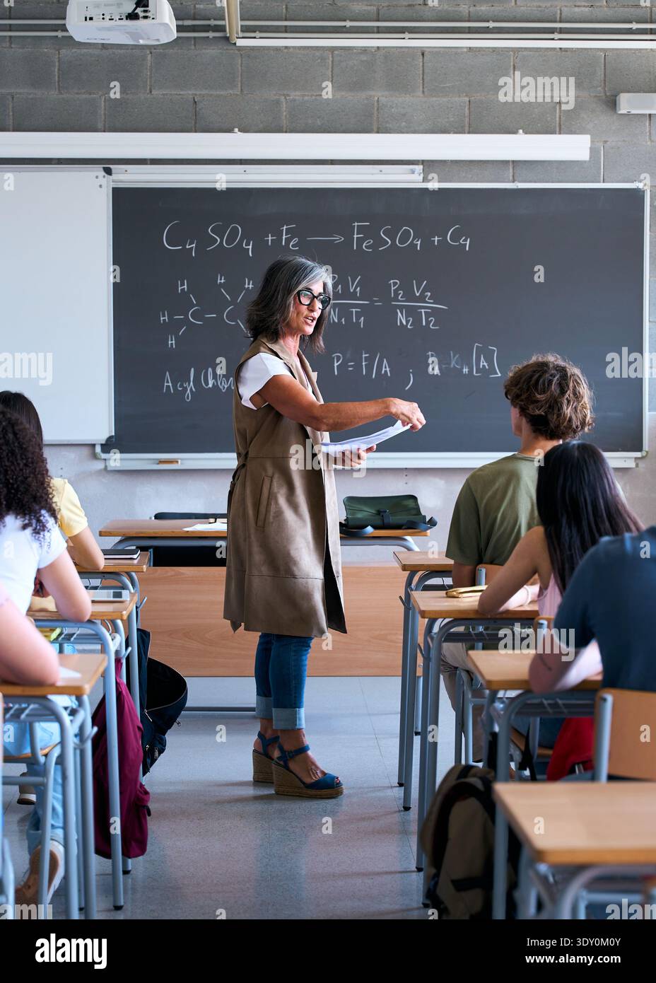 Female teacher explaining science formula to students in classroom Stock Photo