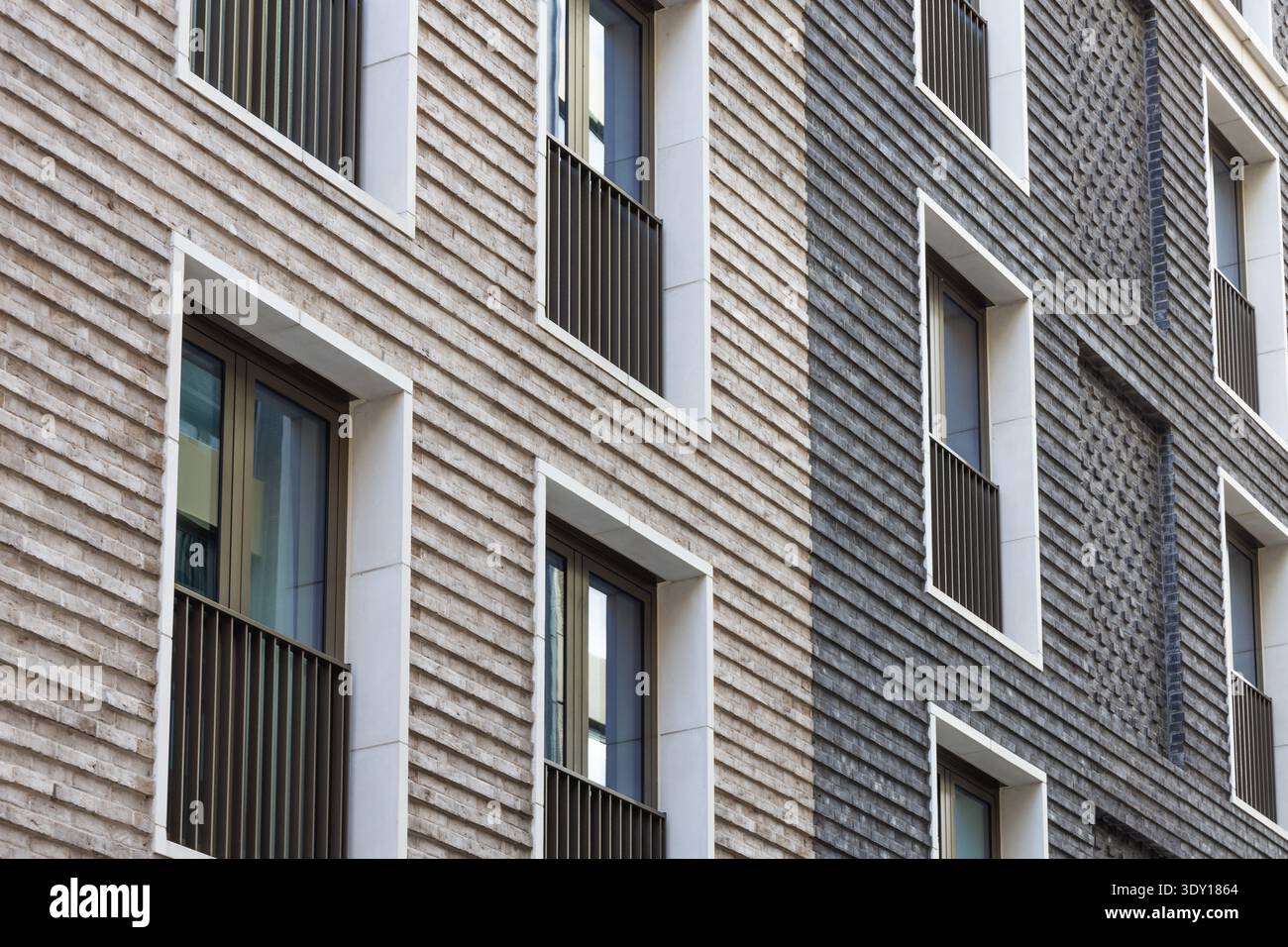 Modern brick facade with textured cladding and windows Stock Photo