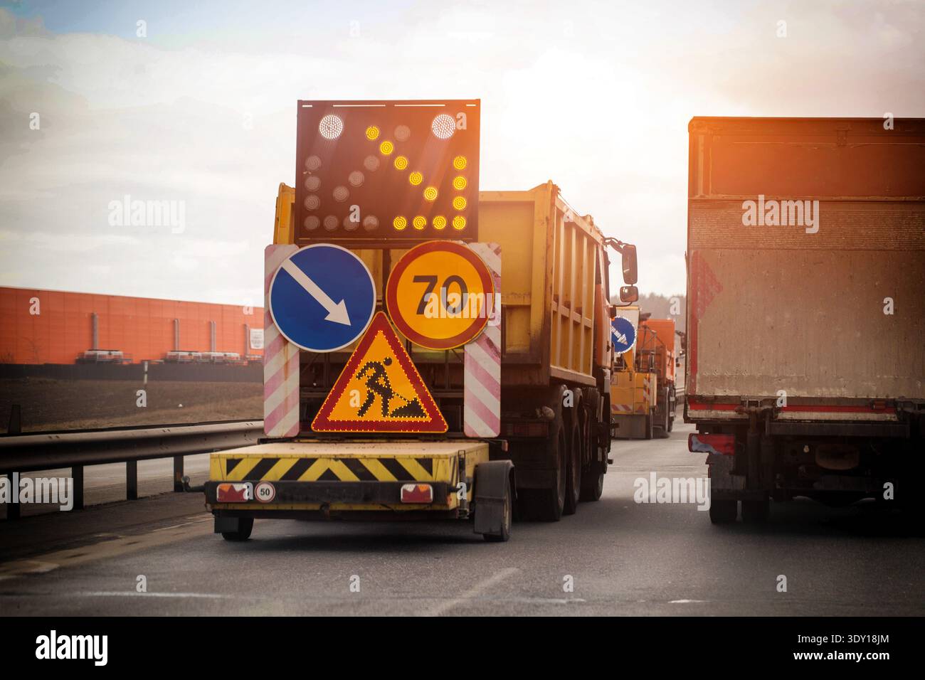 Road maintenance truck rear. Illuminated arrow board directs right ...