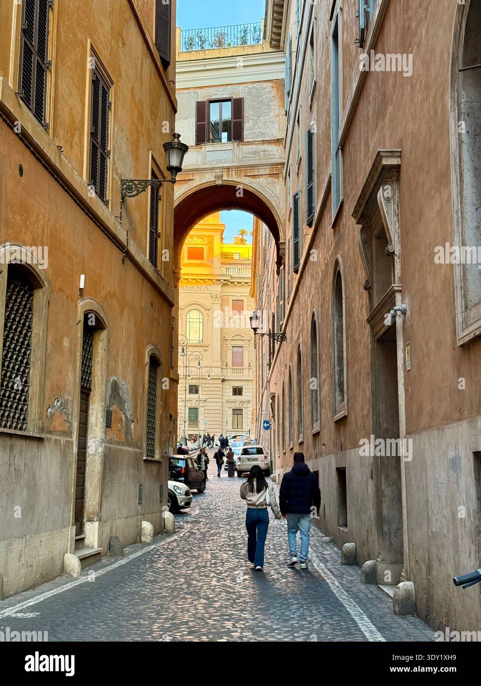 Trevi area of Rome Italy, Via dell’ Archetto with characteristic arch and bridge which connects two buildings.  People walking Stock Photo