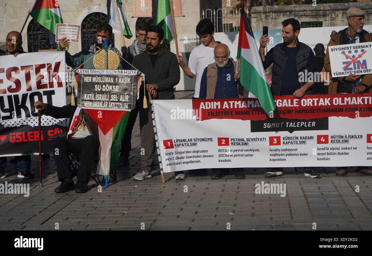 People hold banners and Palestinian flags during a public protest advocating for a boycott in front of the historic Agia Sophia monument. Stock Photo