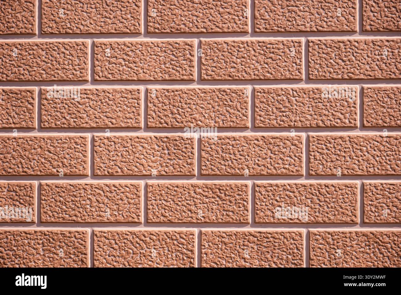 Brown textured brick wall surface creating a repeating pattern and background Stock Photo