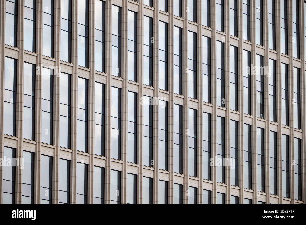 Modern building facade with repeating glass windows creating abstract geometric pattern Stock Photo