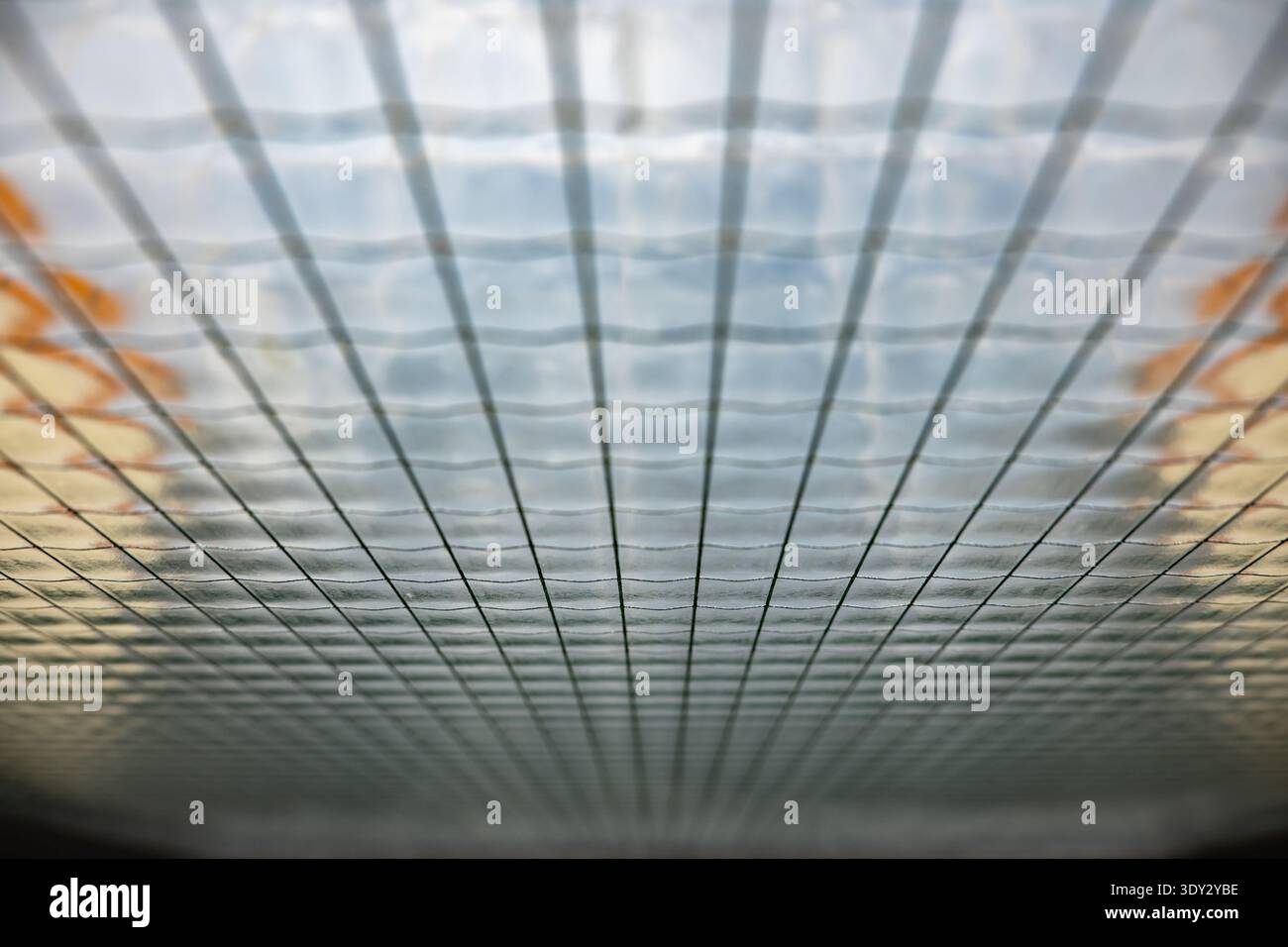 Wired obscure glass ceiling showing grid pattern and abstract reflections indoors Stock Photo