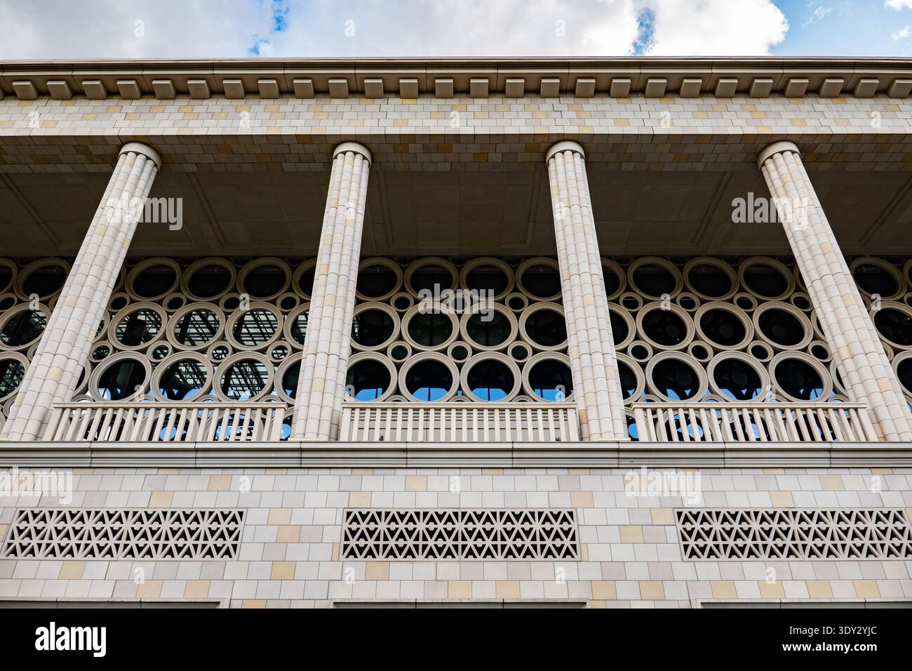 Modernist building facade featuring classical columns and geometric circular windows Stock Photo