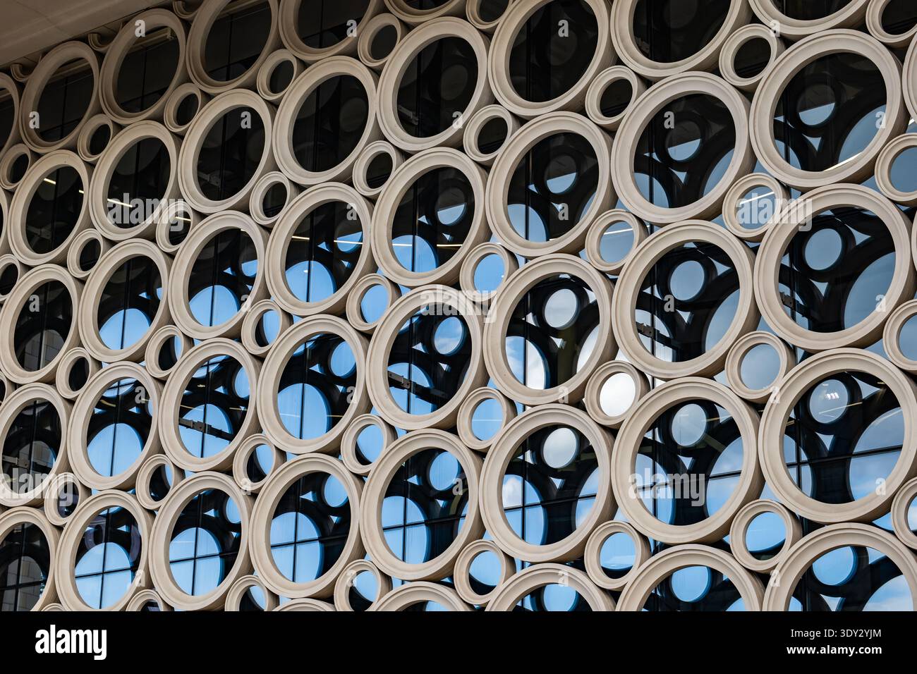 Modern building facade featuring abstract circular pattern and glass windows Stock Photo