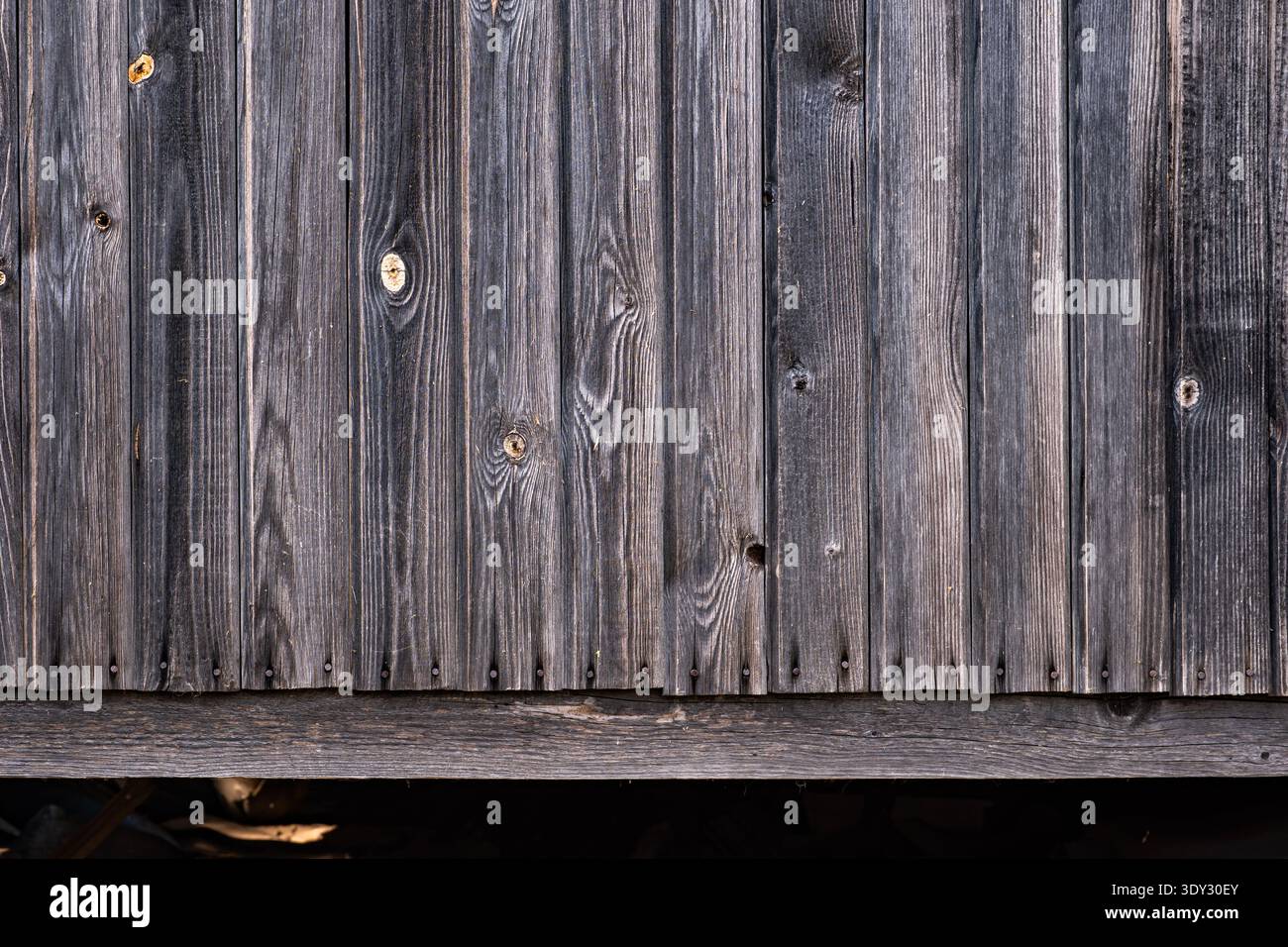 Weathered barn wood planks creating a rustic gray timber wall texture background Stock Photo