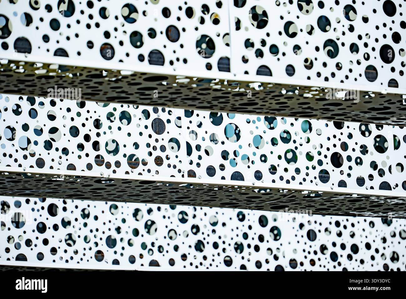Modern building facade creating abstract pattern with multiple perforated circles Stock Photo