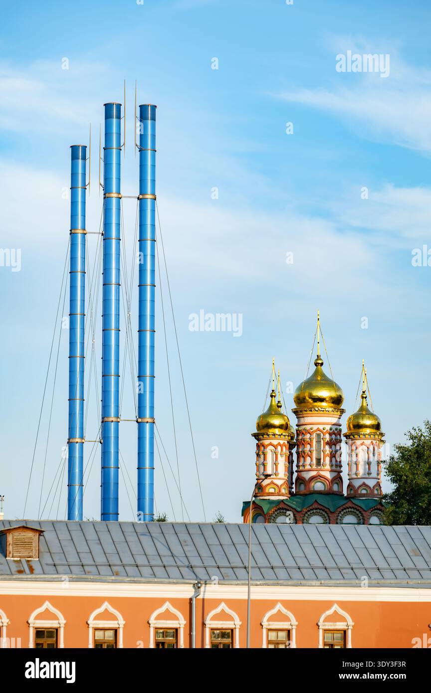 Moscow architecture creating contrast with modern industrial chimneys and golden domes Stock Photo