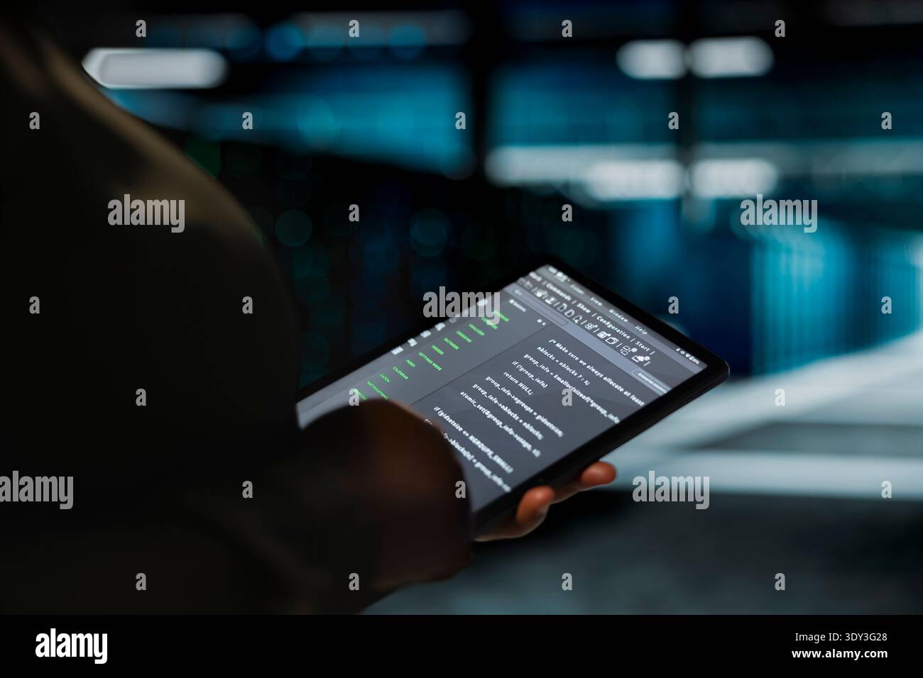 Data center computer scientist using tablet to optimize network infrastructure, planning capacity. Employee managing server room resources with device for improved reliability and uptime Stock Photo