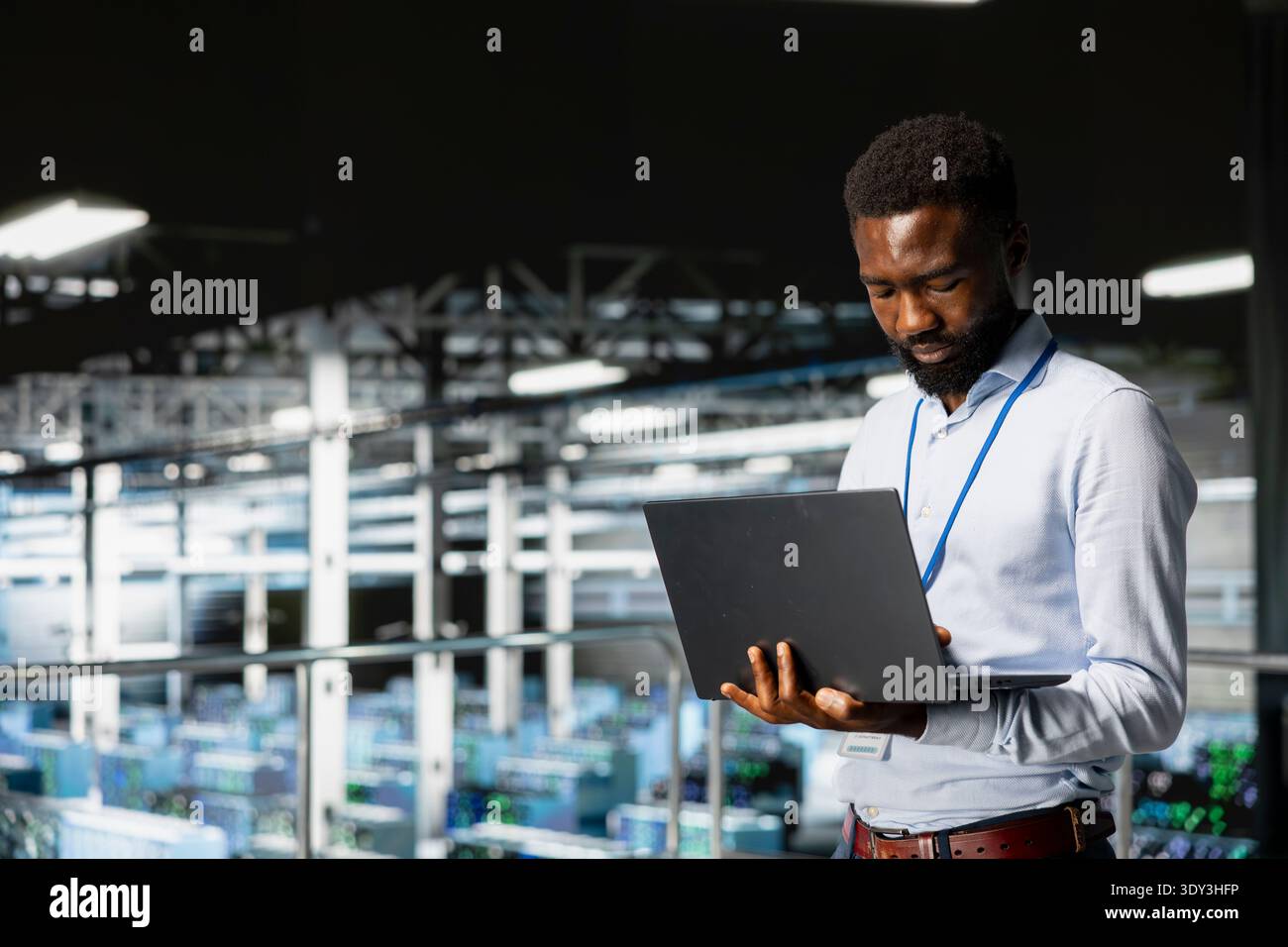 Smiling data center engineer on industrial platform works on neural network software tasks. Jolly african american technician visualizing large language model architecture, technical support. Stock Photo