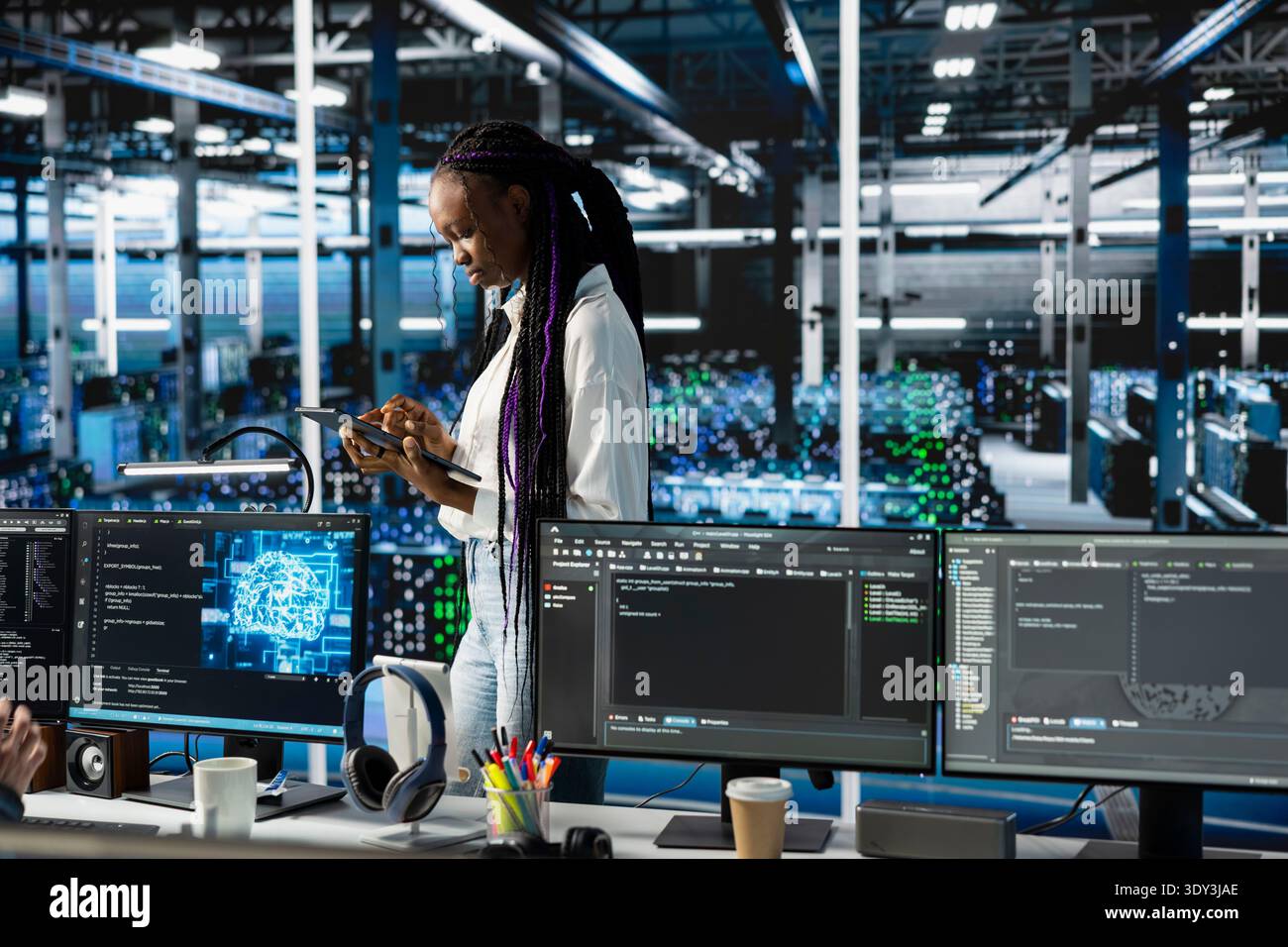 Programmer coding in data center, updating machine learning automation scripts. African american woman in server hub programming artificial intelligence algorithms, debugging equipment racks Stock Photo