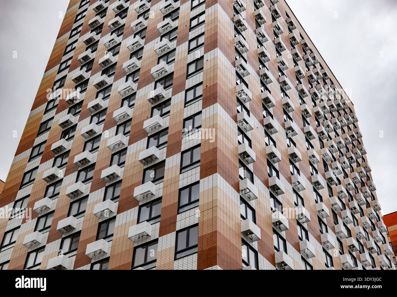 Modern building facade with checkerboard pattern, many windows and air conditioners Stock Photo