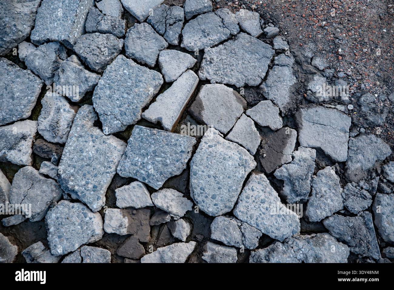 Broken asphalt pavement fragments creating a textured surface background Stock Photo