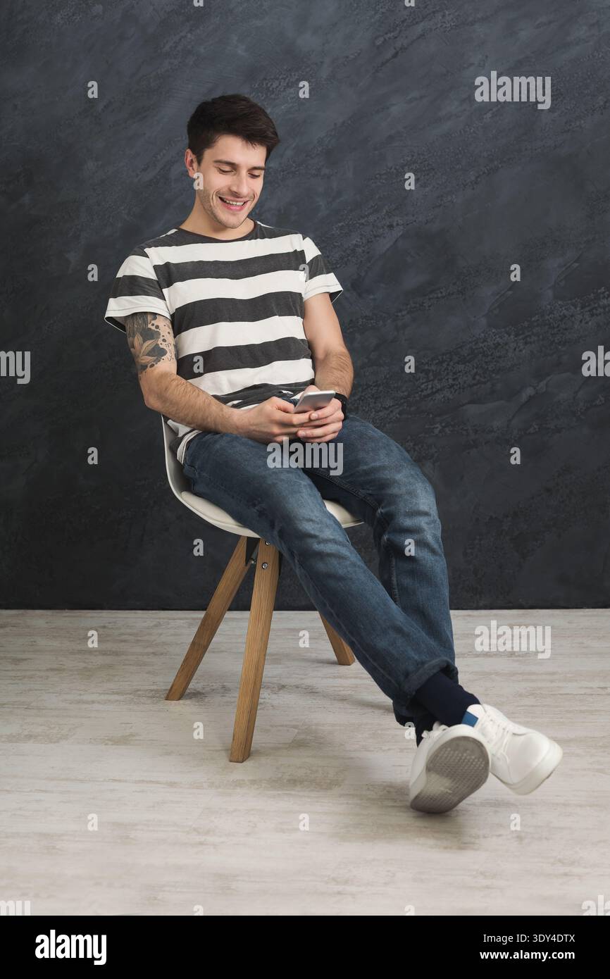 Handsome man using smartphone in studio Stock Photo