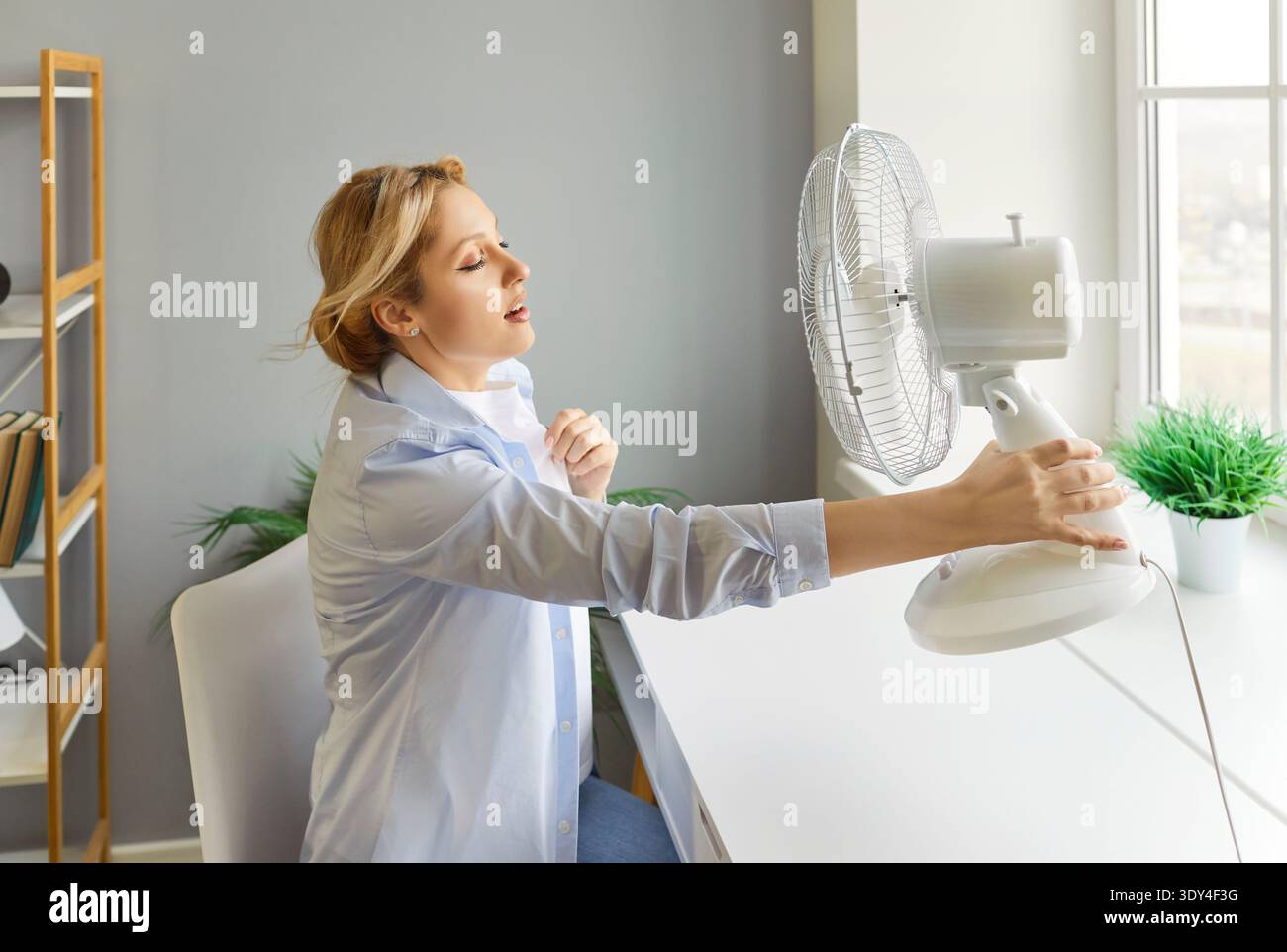 Sweating Woman Using Fan During Hot Weather Stock Photo - Alamy