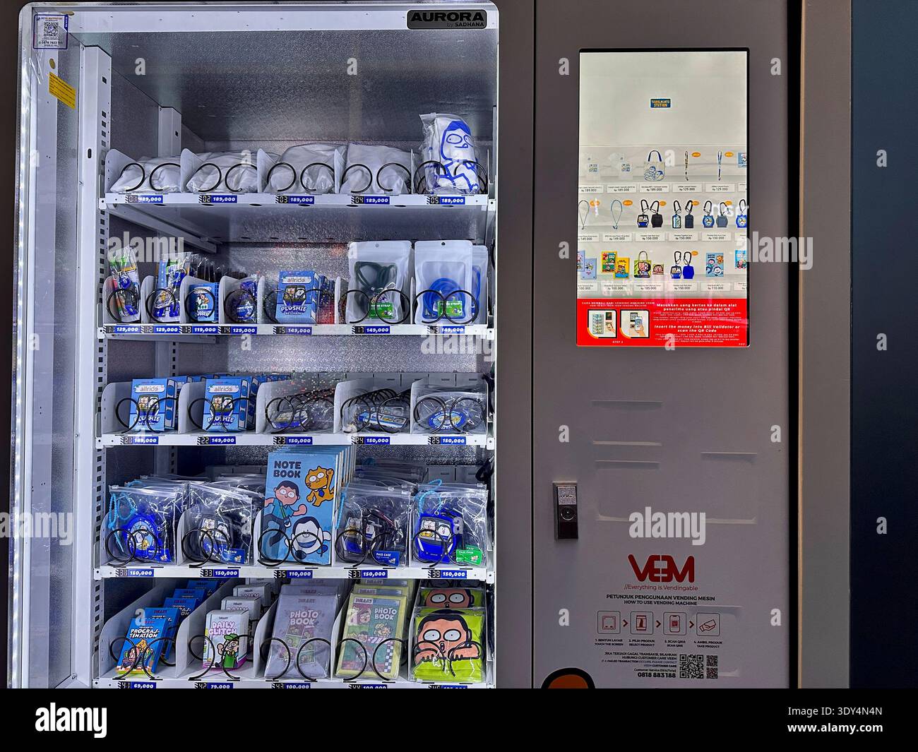 Close view of a vending machine offering Jakarta transport themed merchandise and cartoon souvenirs for commuters and visitors. - Smartphone Captured Stock Image