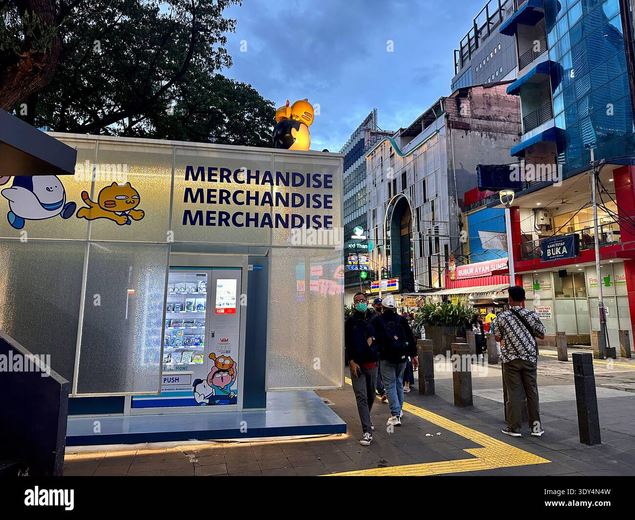 Close view of a vending machine offering Jakarta transport themed merchandise and cartoon souvenirs for commuters and visitors. - Smartphone Captured Stock Image