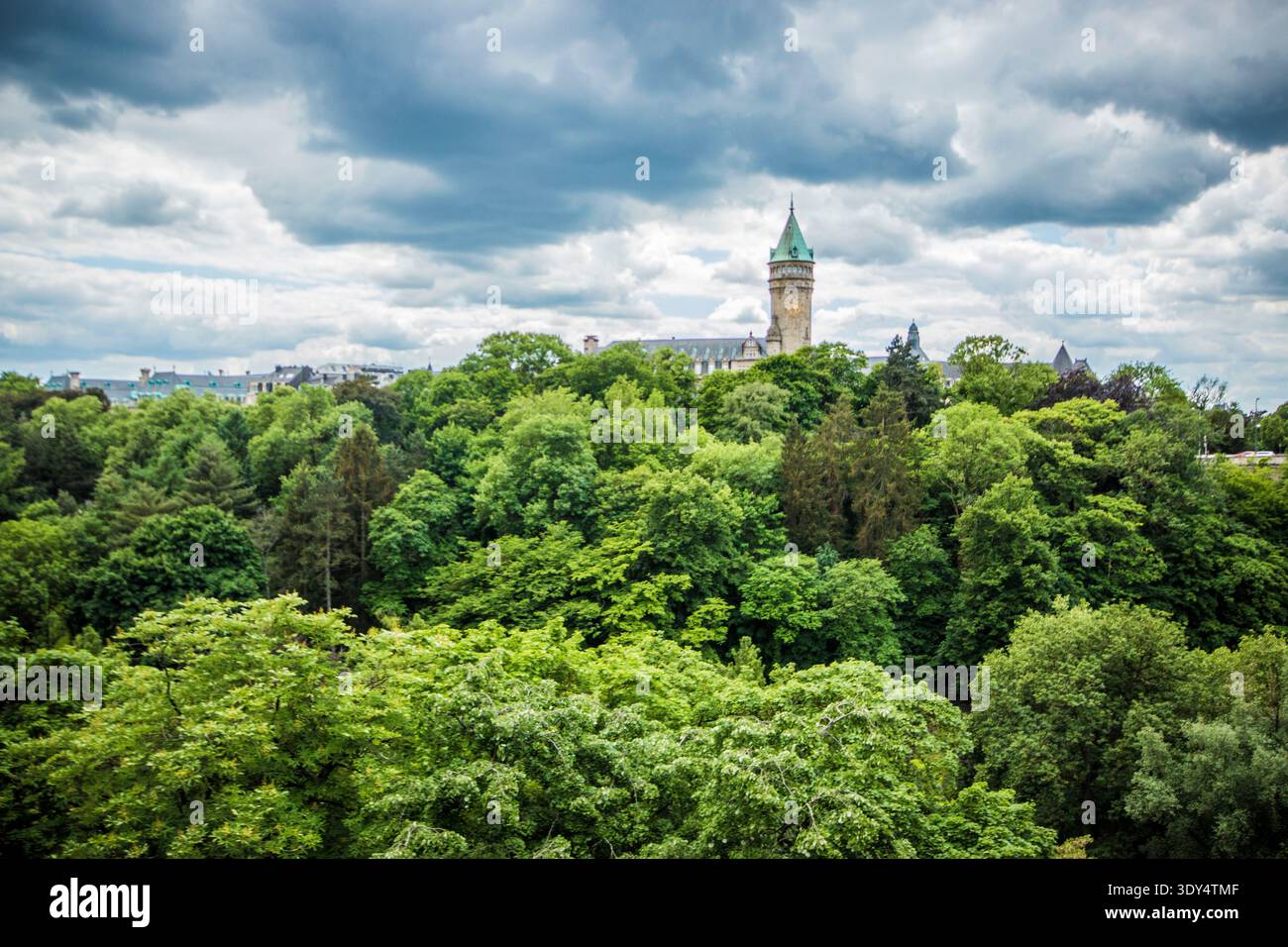 The historic BCEE tower rises above the dense forest canopy of the Pétrusse Valley, Luxembourg City, Luxembourg. Stock Photo