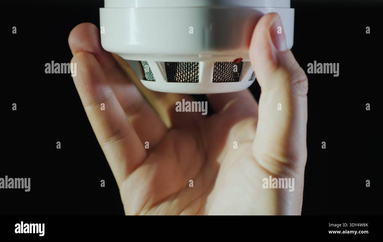 Man installs a sensor fire protection system Stock Photo