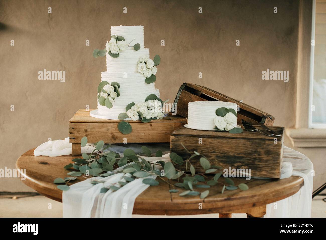White wedding cake decorated with eucalyptus and roses Stock Photo
